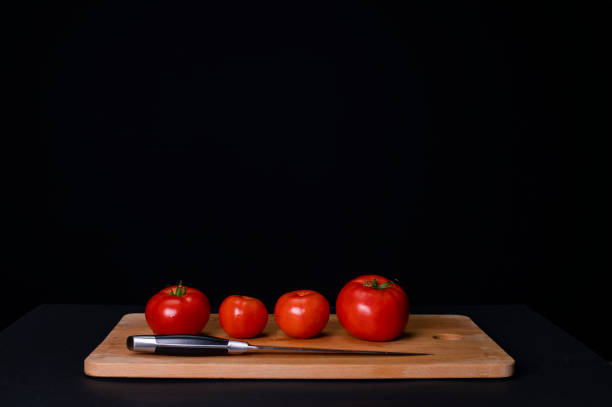 istock Tomatoes on a wooden cutting board 1267006515