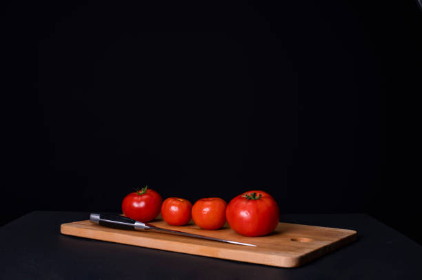 istock Tomatoes on a wooden cutting board 1267006562