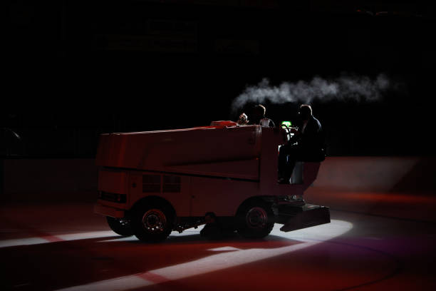 A silhouette of an ice maintenance vehicle preparing the ice surface during game break. stock photo