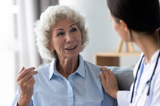 istock Smiling middle aged old woman talking to friendly general practitioner. 1267012044