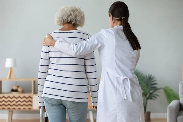 istock Young physiotherapist helping old disabled woman walking with frame. 1267012086