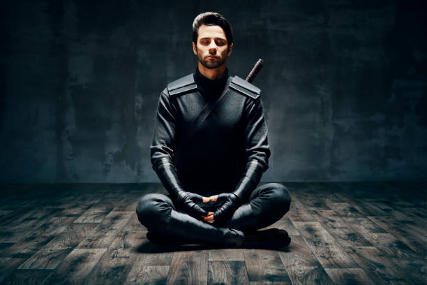 warrior man meditating in lotus pose - ninja imagens e fotografias de stock