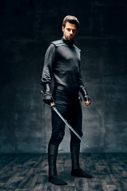 istock Full length portrait of warrior man posing with a sword 1267012210