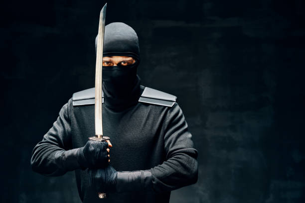 istock Fighting ninja with a sword over black background 1267012238