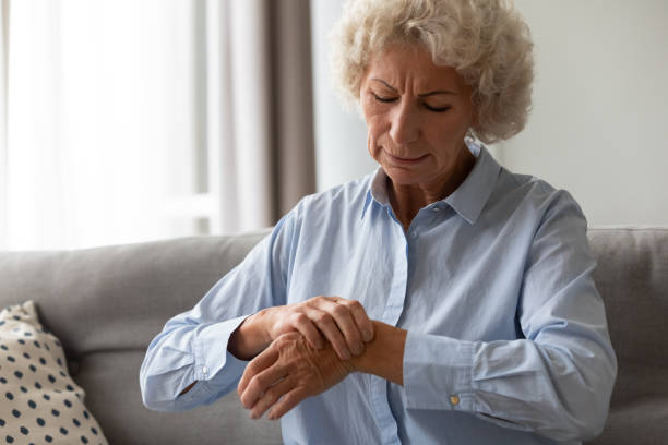 Senior old woman touching wrist joint, suffering from injured hand. Unhappy senior old hoary woman touching wrist joint, suffering from injured hand. Frustrated stressed middle aged mature female retiree having painful feelings in bones, arthritis osteoporosis concept chronic illness stock pictures, royalty-free photos & images