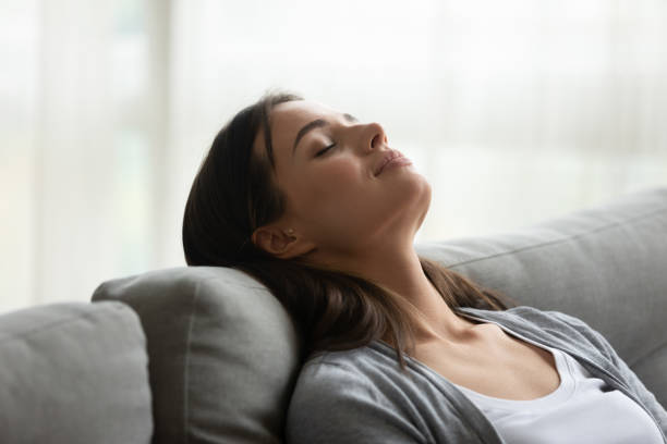 istock Mindful young woman daydreaming alone indoors on couch. 1267013579
