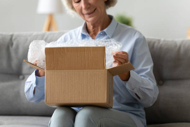 istock Senior female retiree unboxing cardboard container. 1267013582