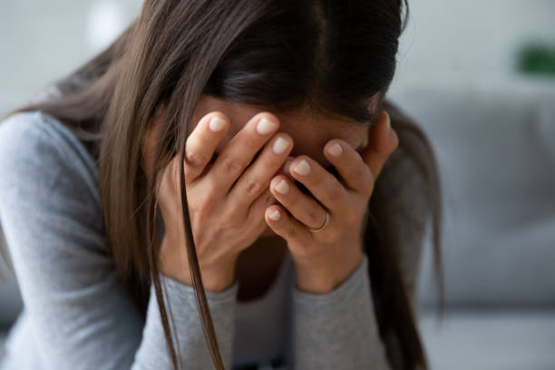 istock Unhappy young woman hiding face in hands, feeling desperate. 1267013586