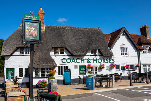 Dorset, UK - August 3rd 2020: A view of the beautiful traditional architecture of the Coach and Horses pub in the market town of Wimborne Minster in Dorset, UK.