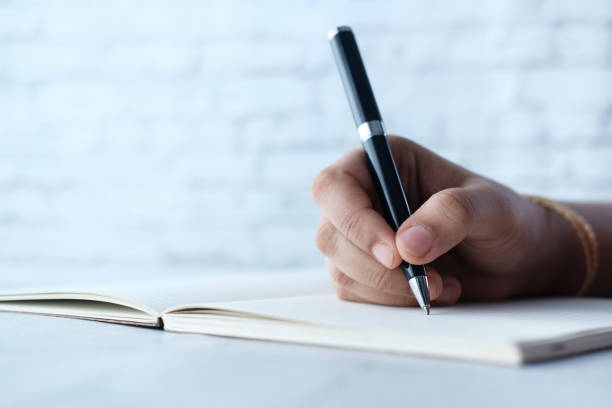 istock Close up of women hand writing on notepad. 1267017140