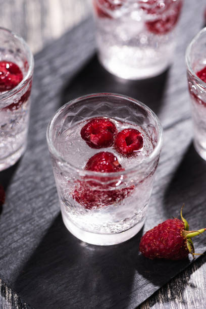 Alcohol shots of berries cocktail with a raspberry