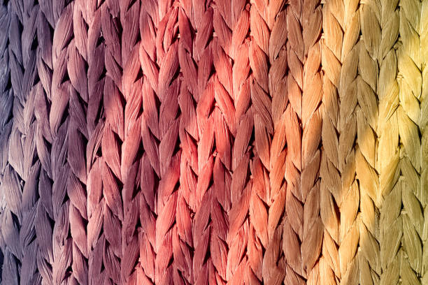 Colorful natural braid illuminated by the sun's rays. Colorful natural braid illuminated by the sun's rays. A natural material for braiding decorative items. Front view of a hand-woven basket. multi colored woven macro mesh stock pictures, royalty-free photos & images