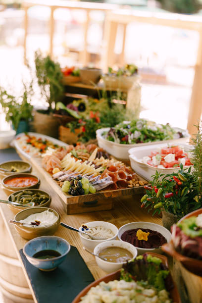 istock Long table with ready-made banquet delicacies and flower pots on a blurred background. 1267021286