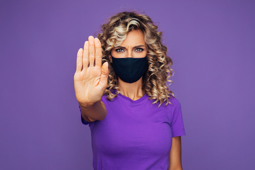 Girl in protective mask with stop symbol