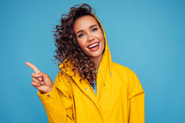 istock Beautiful woman smiling and pointing away 1267021437
