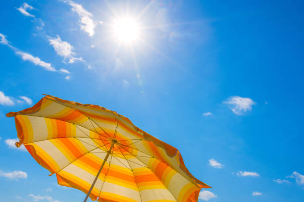 istock Beach umbrella on a background blue sky, in a sunny canicular day 1267029340