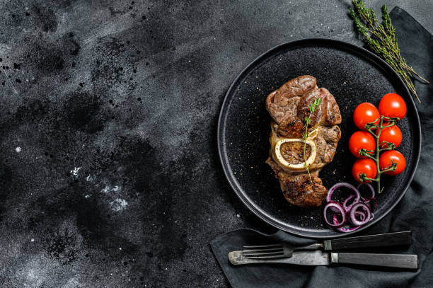istock Osso buco, cooked Veal shank. Ossobuco meat. Black background. Top view. Copy space 1267029368