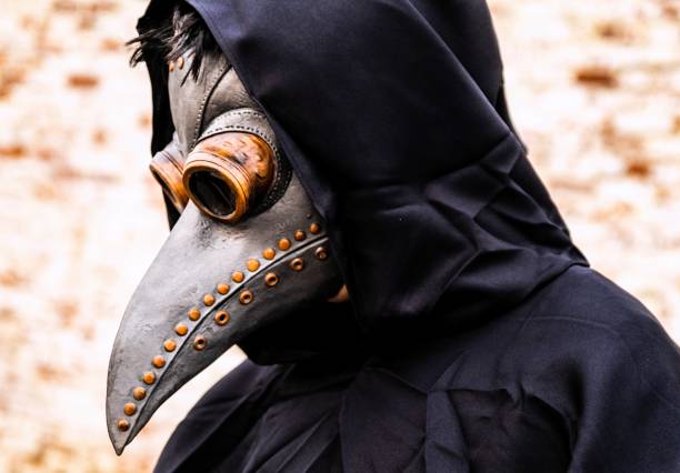 Sinister character doctor wearing an old time pandemic protective face mask Sinister character doctor wearing an old time pandemic protective face mask because Covid-19 pandemic black plague doctor stock pictures, royalty-free photos & images