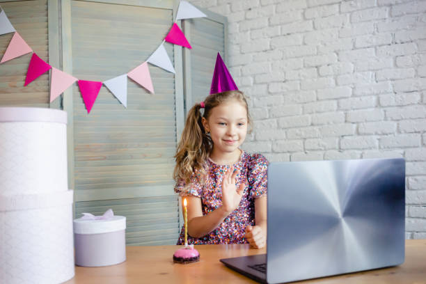 Children celebrating her birthday through video call stock photo