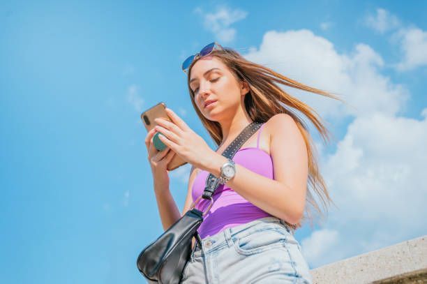 istock Beautiful young woman using her smartphone, smiling and texting 1267032888