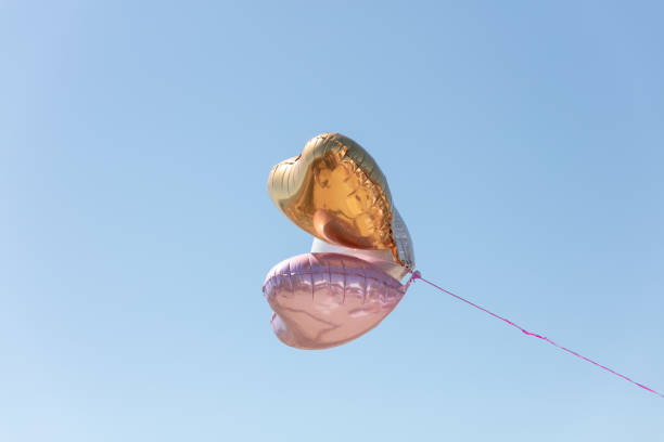 istock Heart-shaped balloons flying in the sky 1267034600