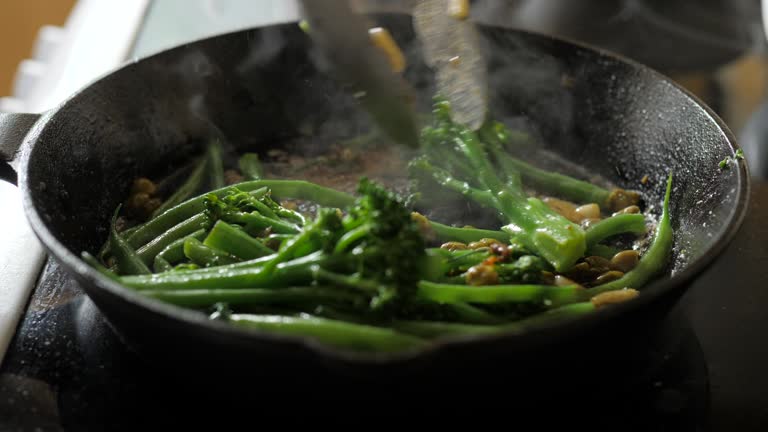 fry off broccoli stem, green beans with sliced garlic and capers on skillet pan