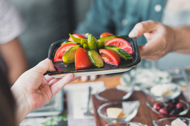 Woman passing the salad bowl
