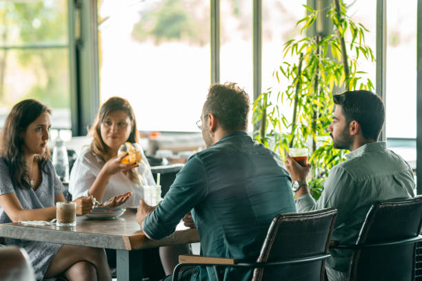 istock Group of people talking each other at restaurant 1267038237
