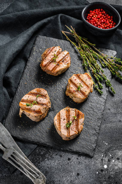 istock Tender boneless grilled pork chops. steak tenderloin. black background. Top view 1267038880