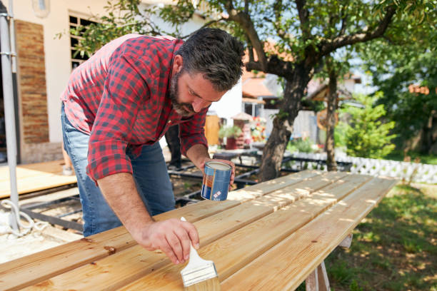 istock Carpenter using a brush with varnish on finished wooden planks 1267039171