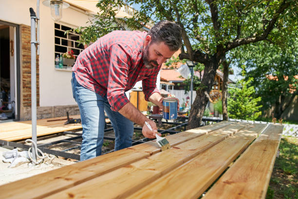 istock Skilled carpenter adding lacquering finish on wooden planks 1267039939