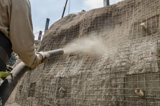 Photo of Concrete pumping hose used to cover with cement a construction wall