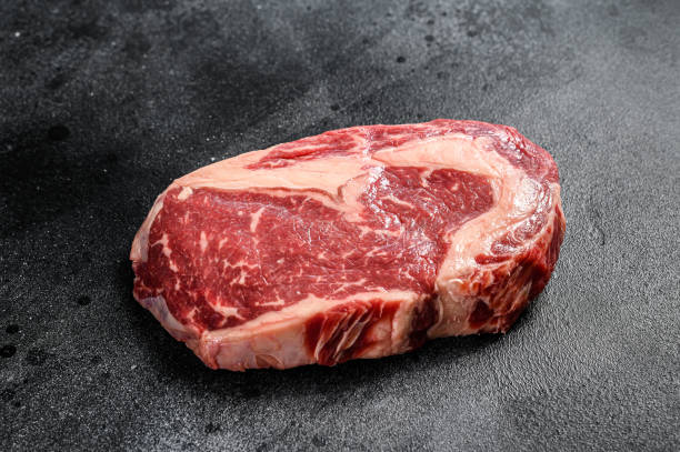 istock Raw Steak Ribeye. Black Angus Rib eye. black background. top view 1267041542