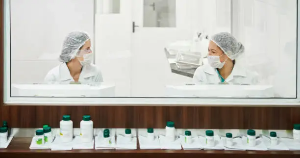 Shot of two female chemists discussing while working together in the pharmacy lab