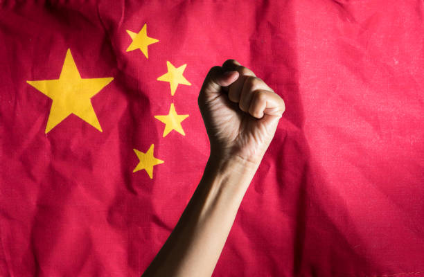 istock Hand with clenched a fist and China flag. 1267047493