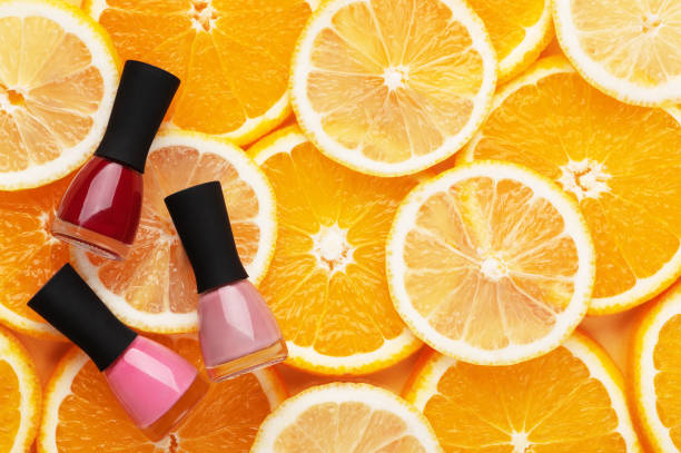 柑橘類の背景の上のビューに多色マニキュア。オレンジとレモンにプロのマニキュアとペディキュアピンクと赤のためのツール。夏のコンセプト、女性の美しさ