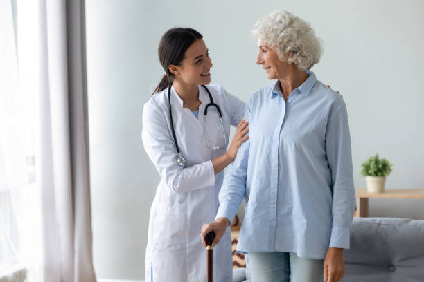 istock Smiling young physiotherapist starting rehabilitation procedure with elderly patient. 1267049016