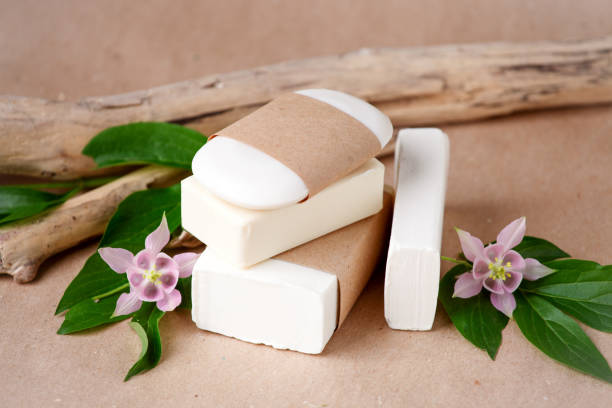 istock Zero waste natural cosmetics products on craft paper table. Flat lay, organic solid soap and shampoo bars, antibacterial handcrafted soap concept, mock up, organic detail, tropical flowers 1267054217
