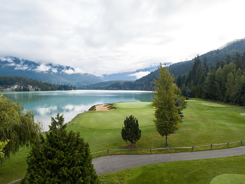 Flag on the putting green. View over the lake onto the putting green. No golfers in view