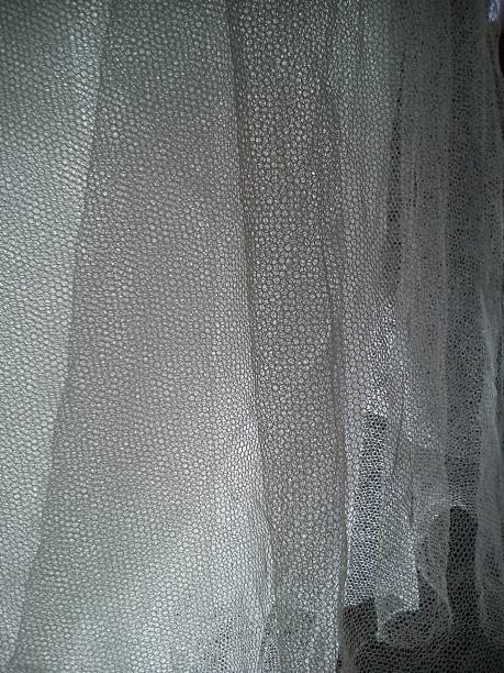 istock White wrinkled mesh fabric. A washable thing made of synthetic material. Mosquito net folded into soft folds. Fabric similar to a bridal veil 1267069092