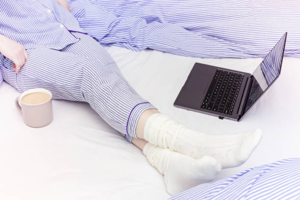 istock Student studying remotely from home in quarantine and pandemic environment, she is dressed in blue-striped pyjamas. Focus on foreground. 1267079155