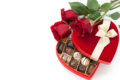 Valentine's Day Heart Shaped Box of Chocolates and Red Roses on white