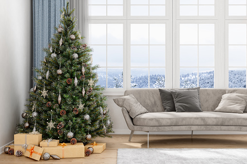 Decorated Christmas tree in the living room with a sofa and large windows
