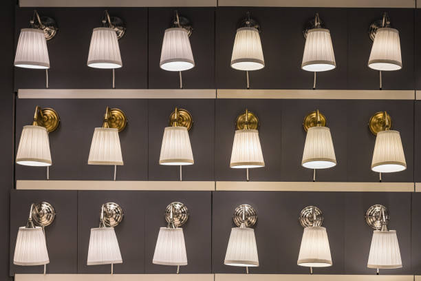 Set of identical fashionable modern beautiful luminous table lamps in the store Set of identical fashionable modern beautiful luminous table lamps in the store. Designer blank with texture effect. gold desk lamp stock pictures, royalty-free photos & images
