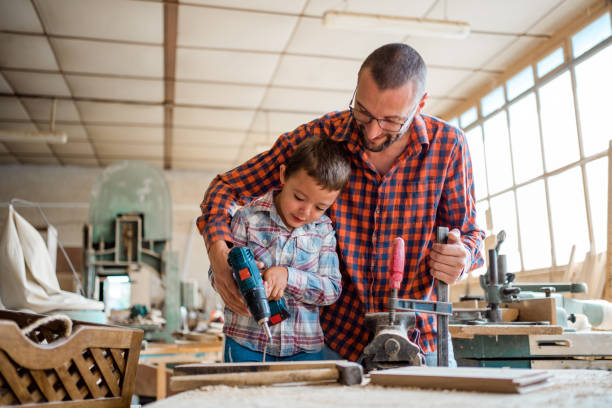 Family carpentry, woodwork and people concept. Woodcarving with father. stock photo
