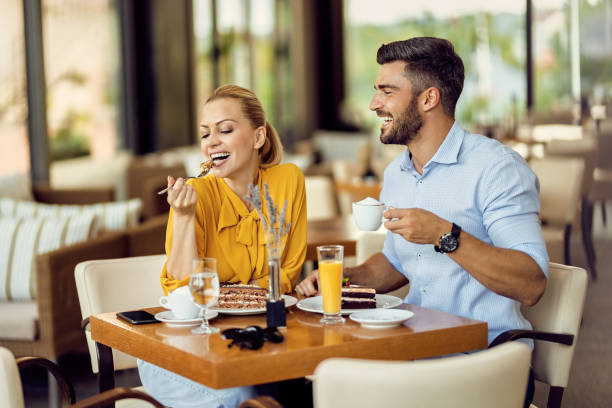 istock Happy couple having fun while eating cake and drinking coffee in a cafe. 1267084828