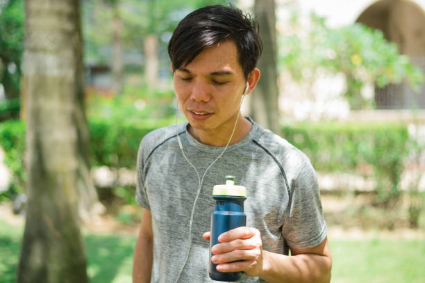 istock Young Asian runner is having a break and drinking water 1267085950