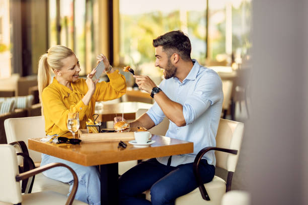 istock Cheerful couple having fun while taking picture with smart phone during lunch in a restaurant. 1267085962