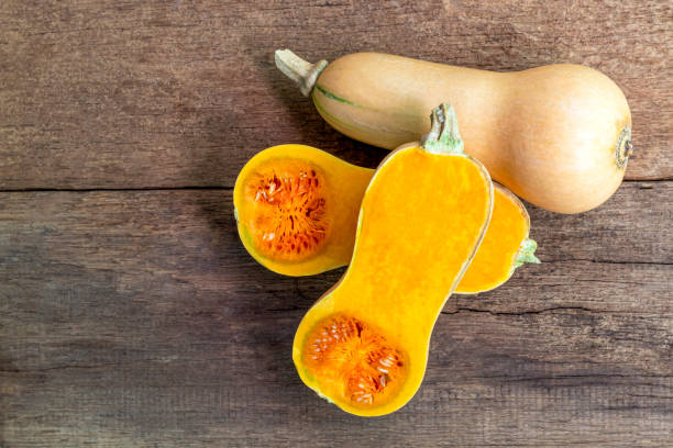 istock Butternut squash whole and sliced on a wooden table. Butternut is a bell-shape fruit with sweet orange-yellow flesh. 1267086085