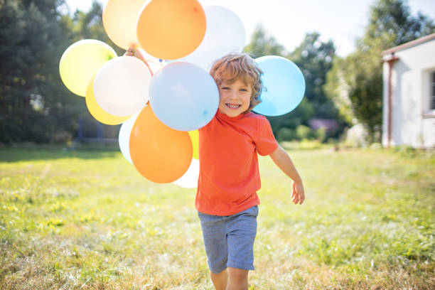 4 years old boy with colorful balloons outside Small four years old boy playing with colorful balloons outside. childrens day photos stock pictures, royalty-free photos & images